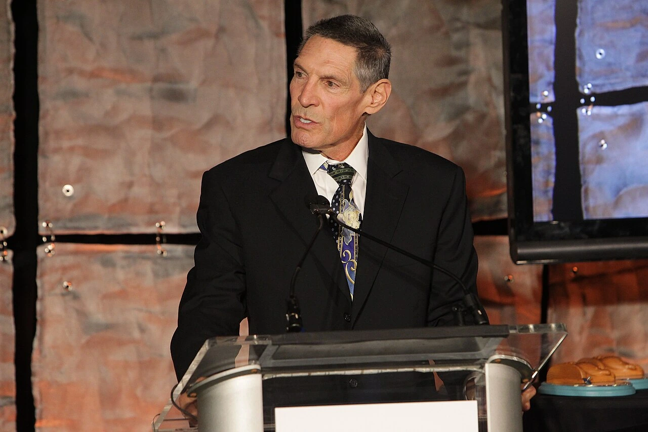 Dr. Gary K. Michelson speaking at a podium at a gala event